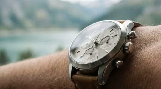Chronographe mécanique suisse au poignet, détail des poussoirs et compteurs