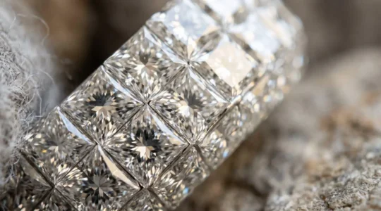 Gros plan sur un serti invisible de diamants dans une bague de haute joaillerie suisse